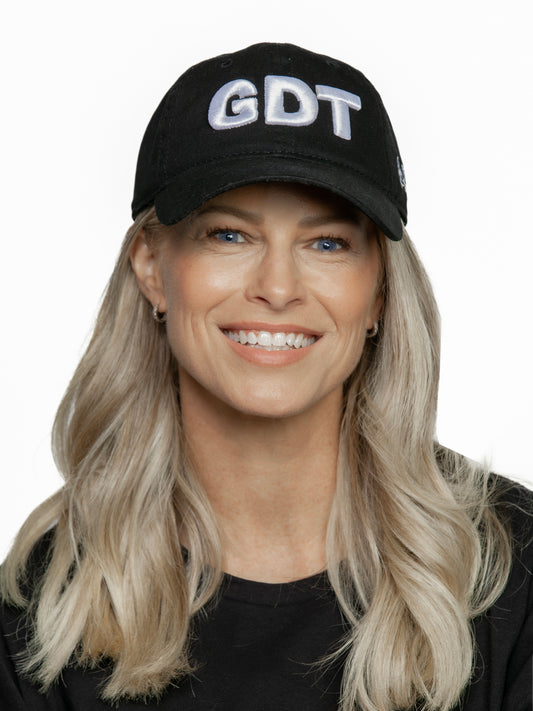 Person wearing a black cap with 'GDT' on a white background