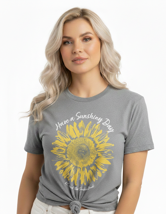 Woman wearing a gray t-shirt with a sunflower design and text.