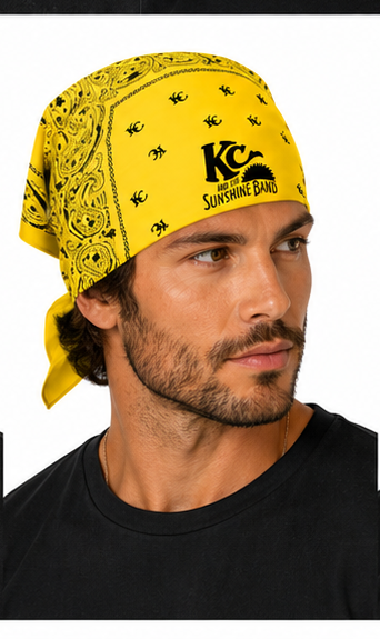 A man wearing a yellow bandana with black paisley patterns and a black 'KC Sunshine Band' logo, shown in a close-up profile shot against a white background.